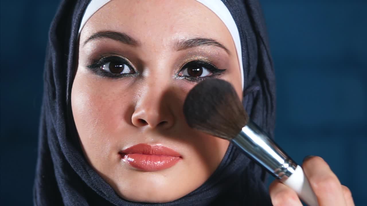 Woman Applying Makeup in Hijab
