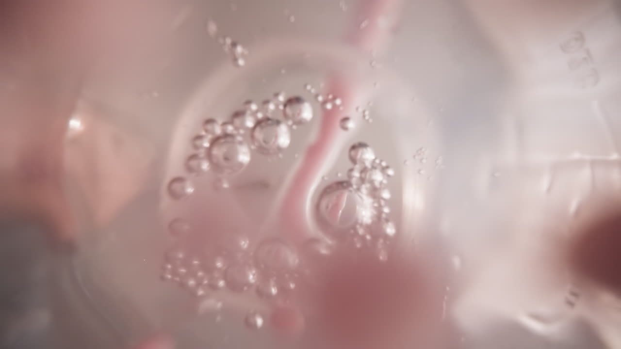 여자는 달 ⁇ 한 베리 맛을 위해 라즈베리 볼을 용해합니다.