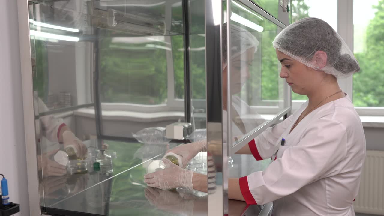 una vista lateral de un laboratorio médico en el que los científicos realizan las pruebas de microbiología en un gabinete de flujo de aire laminar en la sala de pruebas de límite microbiológico.