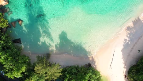 Drohnenaufnahmen-Aus-Der-Vogelperspektive-Von-Weißem-Sandstrand,-Ruhigem-Türkisfarbenem-Meer-Mit-Granitsteinen,-Mahe,-Seychellen-60fps