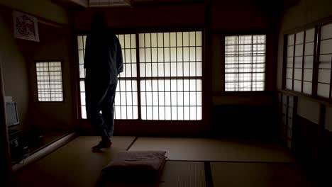 wide shot of an asian man opening the door on the inside to check of nobody is there