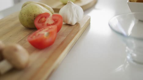 Vegetables-and-garlic-on-wooden-chopping-board-in-kitchen