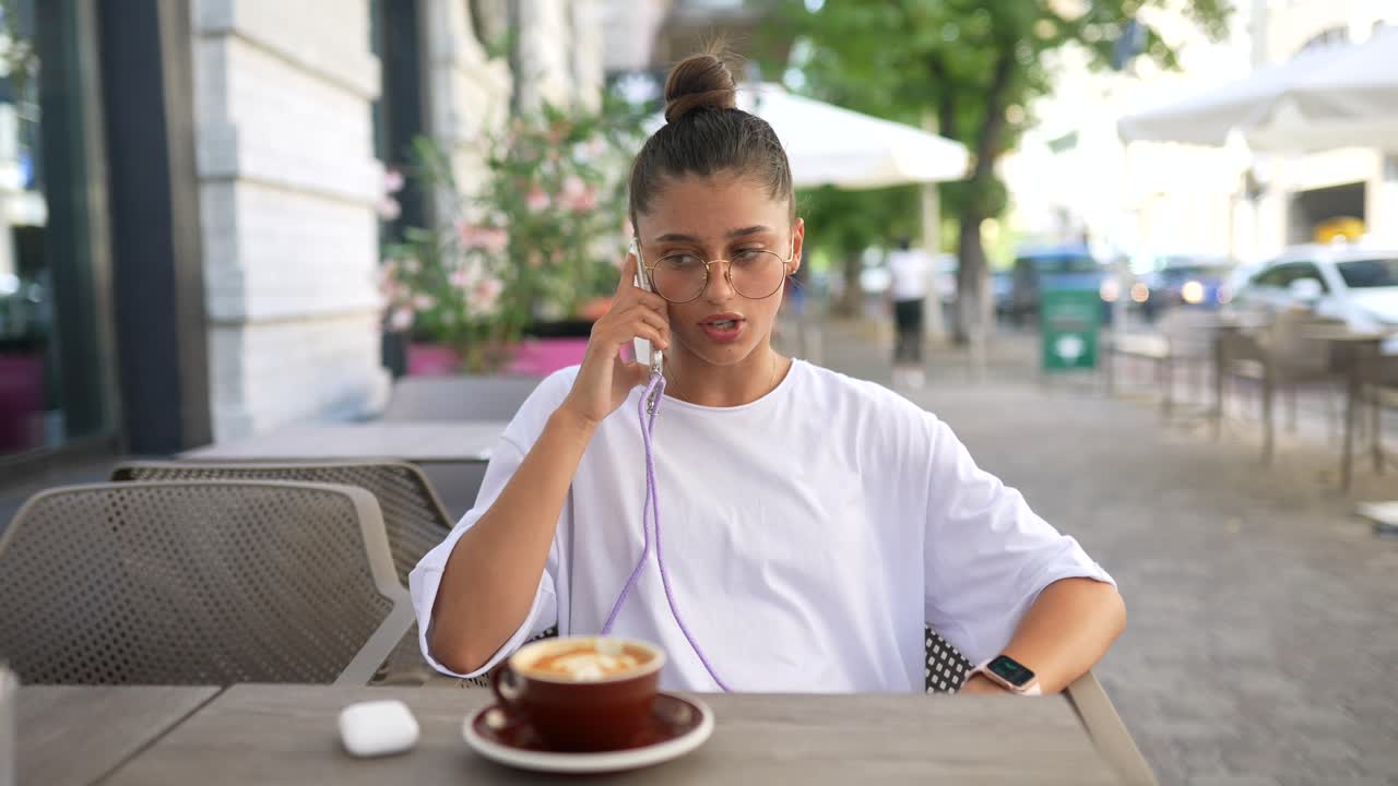 una mujer molesta hablando por teléfono en un café.