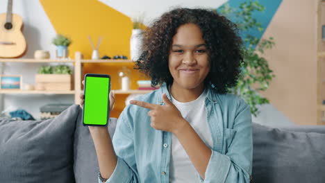 teenager presenting a green screen smartphone