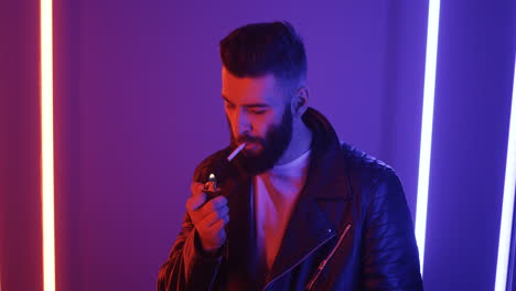 vista de cerca del joven encendiendo un cigarrillo en el fondo de las luces de neón púrpura