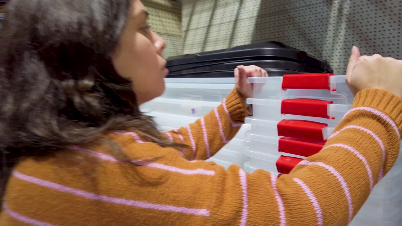 A woman is holding a clear plastic container in a store, is many different types of containers