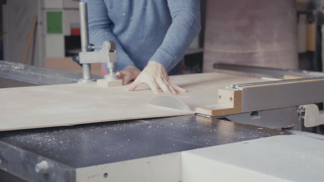 carpintero cortando una hoja de madera contrachapada con una sierra de mesa