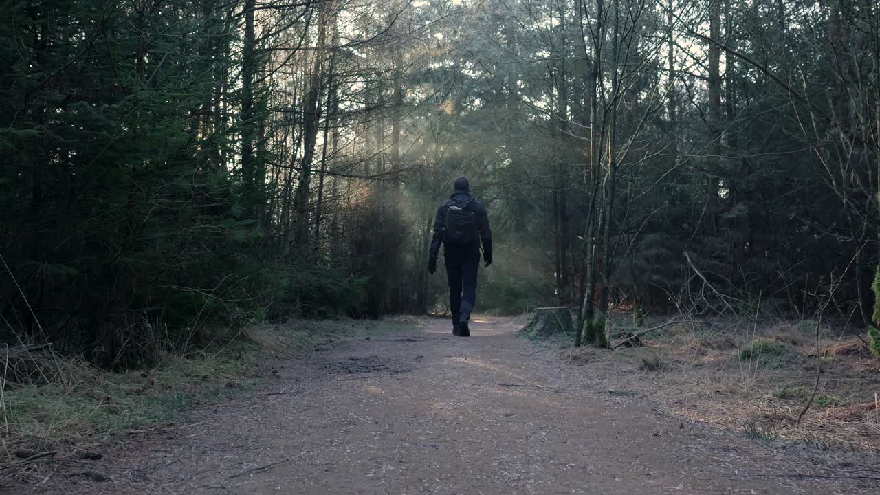 hombre caminando en un bosque de invierno