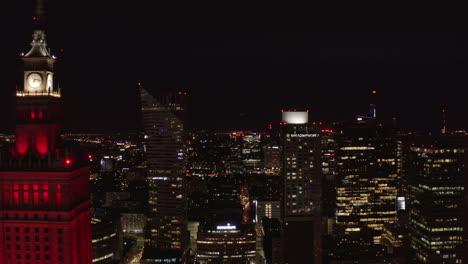 Slider-of-night-downtown.-Revealing-modern-tall-skyscrapers-contrasting-with-historic-PKIN-high-rise-building.-Warsaw,-Poland