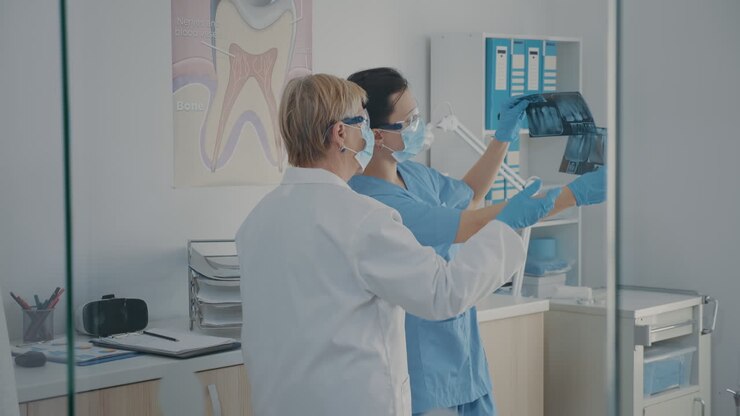 Senior dentist and assistant examining denture x ray results