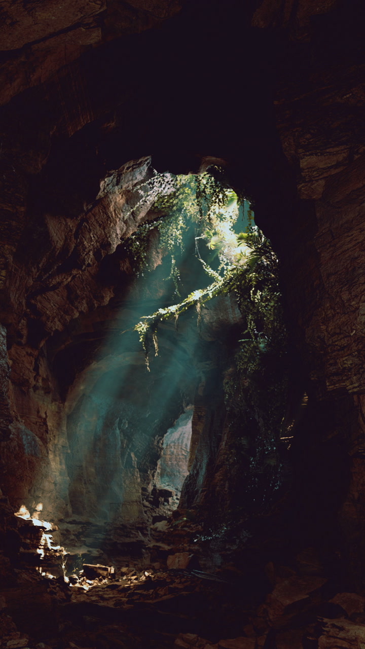 Light streams through a mossy cave illuminating a hidden world within