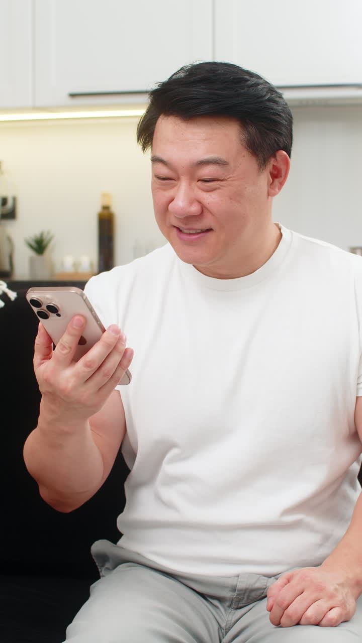 Asian man on phone speakerphone explains choice with gestures ends call with kind friendly farewell