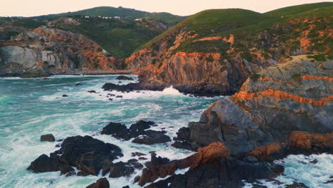 aerial ocean breaking cliffs morning. water crashing rugged stones sea foaming