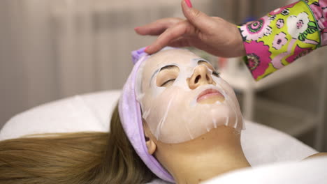 woman receiving a facial mask treatment at a spa