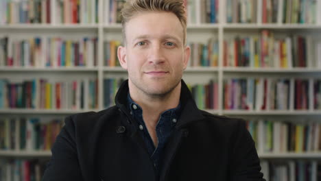 portrait of young successful businessman entrepreneur smiling looking at camera arms crossed confident male in library background