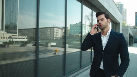 Primer-Hombre-Caminando-Con-Teléfono-Al-Aire-Libre.-Hombre-Molesto-Hablando-De-Teléfono-Inteligente-En-La-Calle