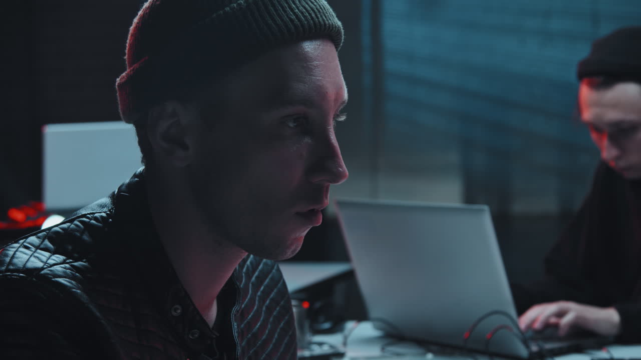 Hacker Using Computer in Dark Hideout