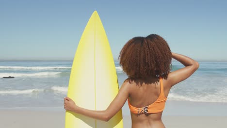 mujer afroamericana lista para ir a surfear