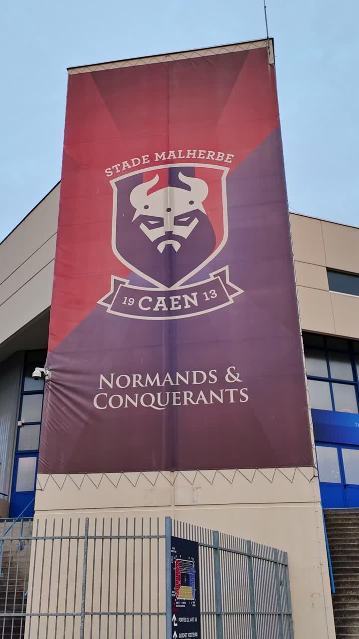 Approaching movement to the bigger Caen Malherbe Stadium banner sign near the entrance, Caen, France