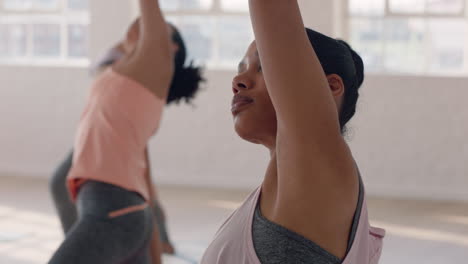 yoga class portrait beautiful mixed race woman practicing warrior pose enjoying healthy fitness lifestyle training in workout studio