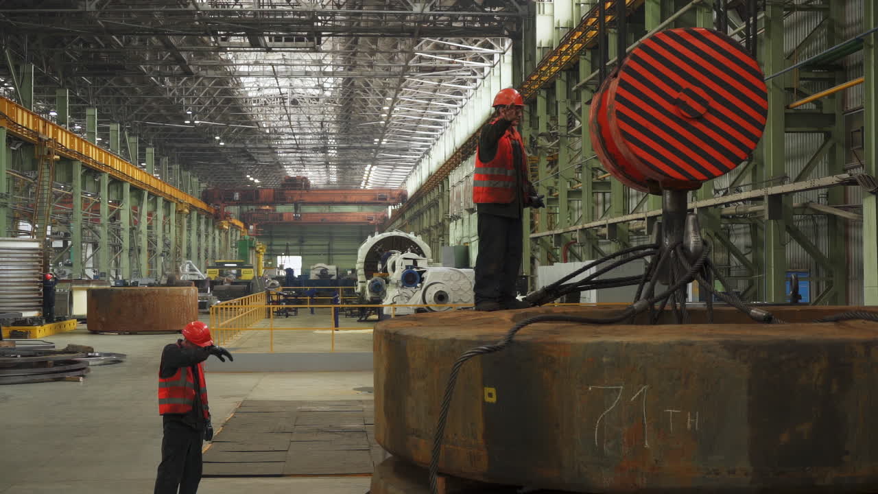 Operai industriali che movimentano grandi lamiere