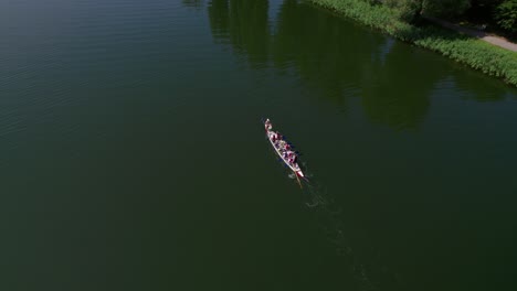 dragon boat swimming on a lake, drone shot