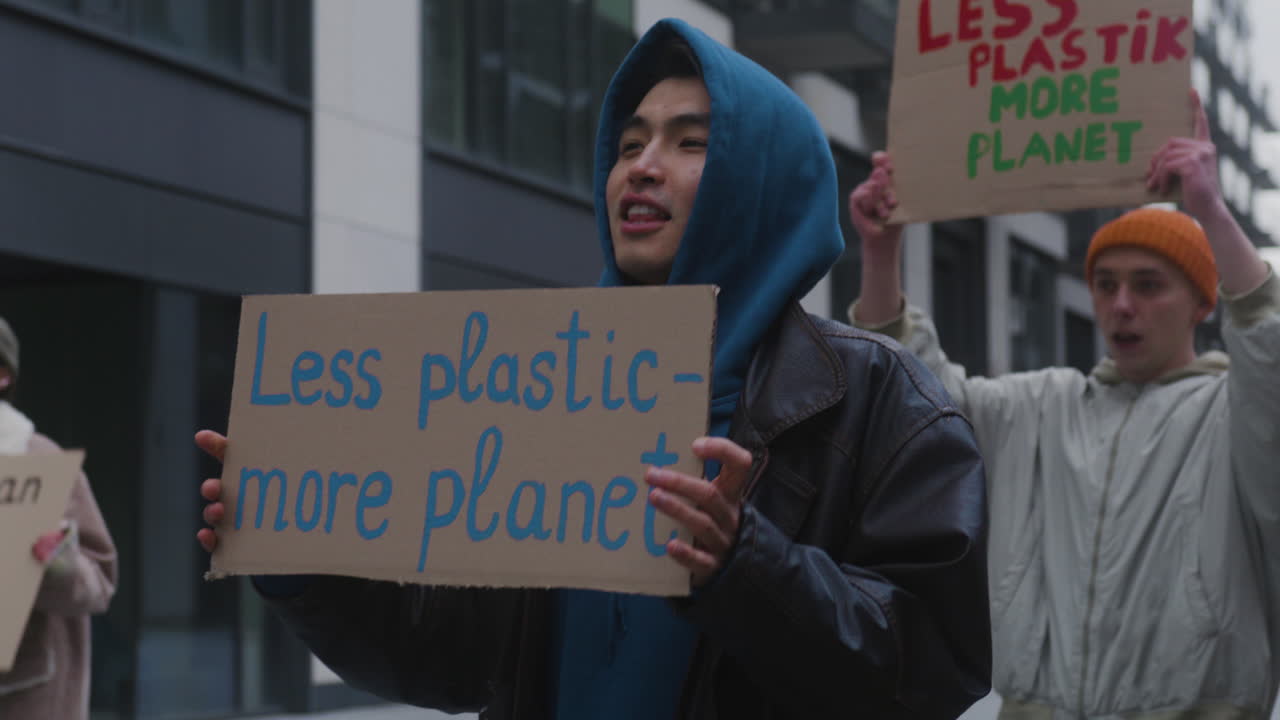 현수막을 들고 플라스틱 사용에 반대하는 젊은 남성 기후 운동가들