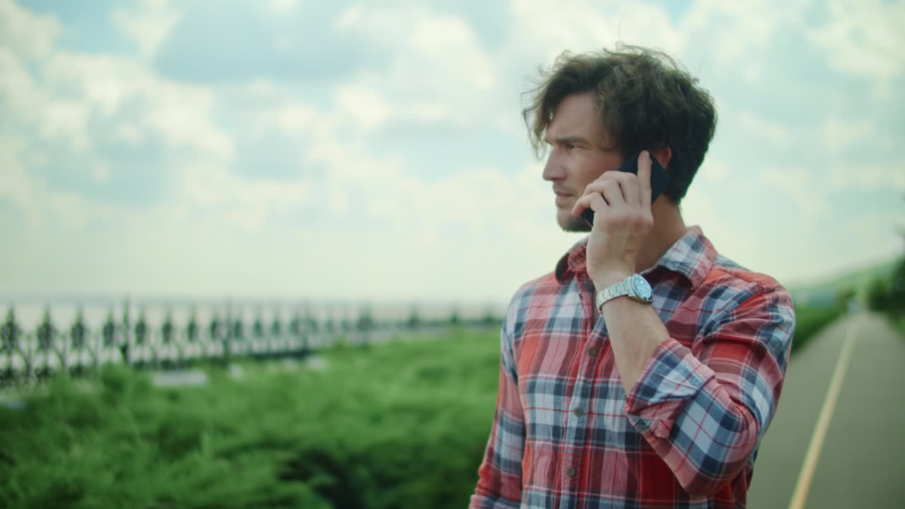 공원에서 스마트폰으로 이야기하는 남자. 길을  ⁇ 고 있는 휴대폰을 가진 남자