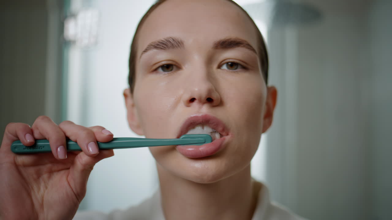 Closeup hands squeezing toothpaste from tube. Morning girl brushing teeth home