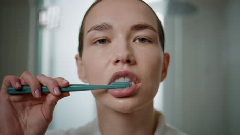 closeup hands squeezing toothpaste from tube. morning girl brushing teeth home