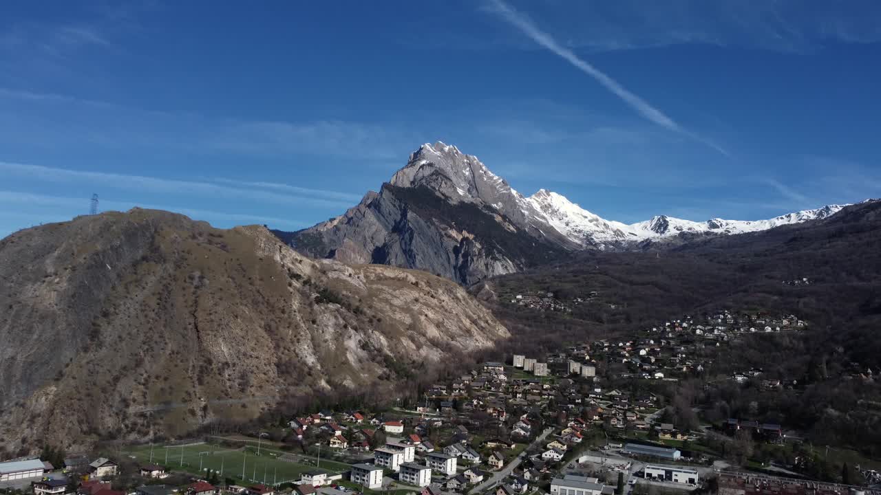 Aerial view of a village near mountains with snow