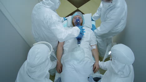 hospital workers running with coronavirus patient on gurney