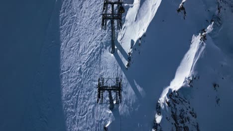 a ski lift arrives at the top of a snow-covered mountain