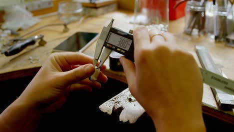 jewelry designer using caliper in workshop 4k