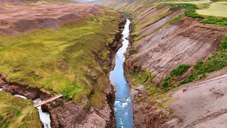 two narrow rivers flowing among the rocks meet in one. drone footage above the mountainous scenery of iceland.