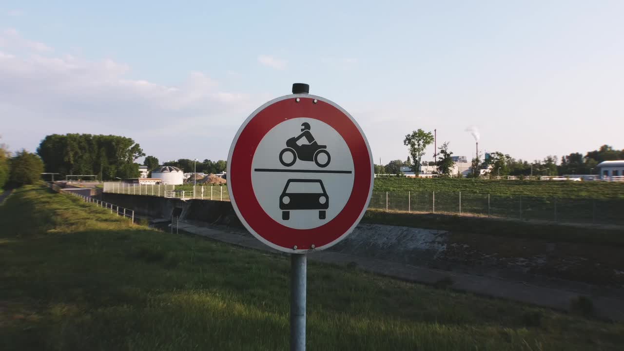 drone footage of an european roadsign automobiles and motorcycles prohibited flying away in the distance on a sunny day