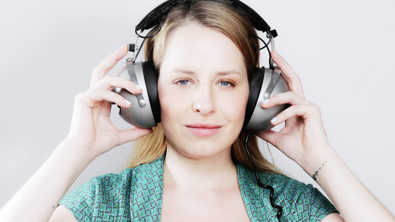 cool female dancer with changing retro headphones to listen to music