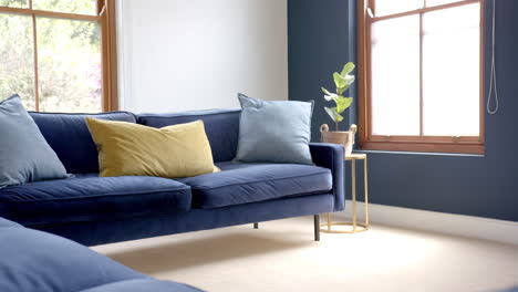 cushions on two blue sofas in sunny living room, copy space, slow motion