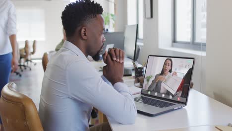 African-american-businessman-using-laptop-for-video-call-with-biracial-business-colleague