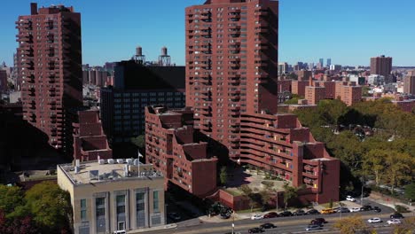 Long-side-moving-drone-shot-starting-on-apartment-highrise-buildings-in-NYC-panning-down-to-following-traffic-on-the-FDR-Drive-along-the-Harlem-River-in-Manhattan