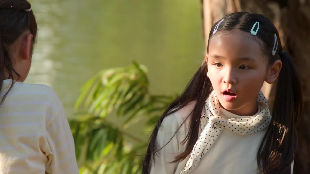 夕暮れ時、ルンピニー公園の湖のほとりで話す二人の少女のクローズアップショット。