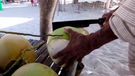 Mann-Hackt-Eine-Kokosnuss-Am-Strand