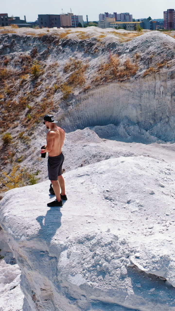 Professional bodybuilder posing outdoors. Concept of beautiful healthy body. Aerial view Vertical video