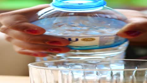 vertiendo agua de una botella en un vaso