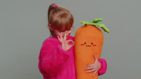 young toddler school girl in sweater looking approvingly at camera showing okey gesture, like sign