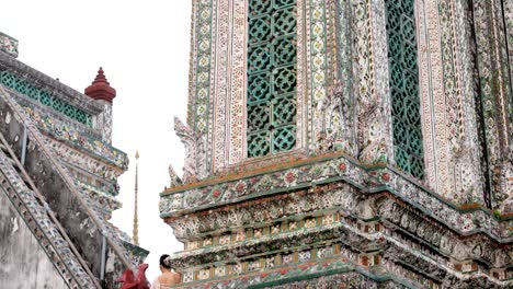 tourists admire wat arun's detailed temple design