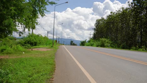 static view of a quiet road in southeast asia where few vehicles pass by on a sunny day