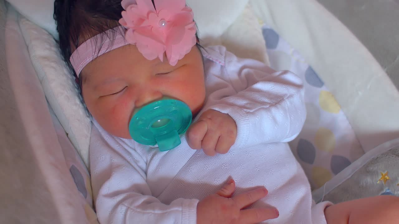 새로 태어난 아기가 잠을 자고 바운서에서 흔들리고 있다