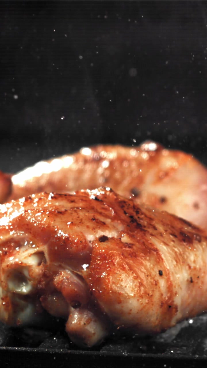 Primo piano di cosce di pollo che sfrigolano su una griglia calda