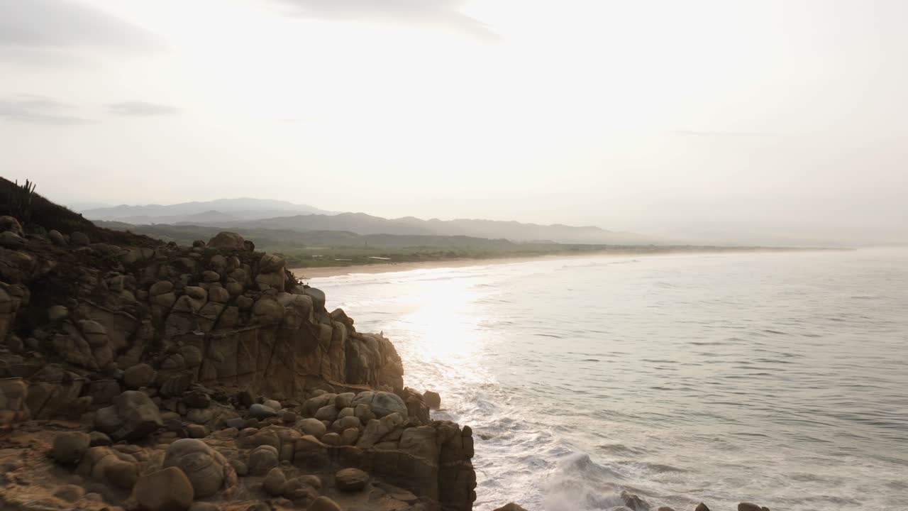 el avión no tripulado se eleva a lo largo del borde de acantilados erosionados con el spray del océano en erupción al atardecer en puerto escondido oaxaca méxico